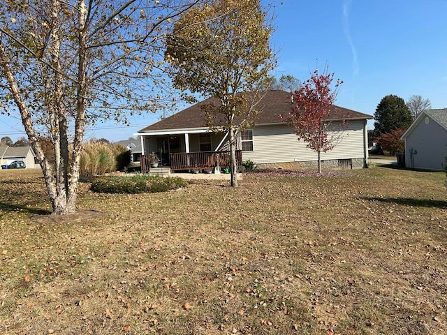 rear view of property featuring a yard and a porch