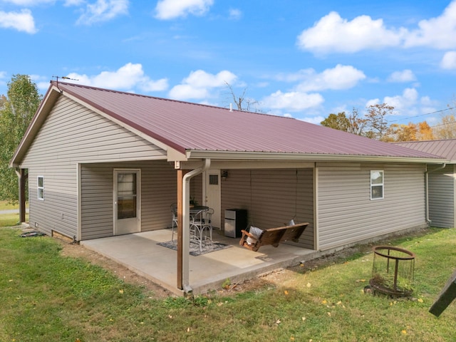 rear view of property featuring a patio and a lawn