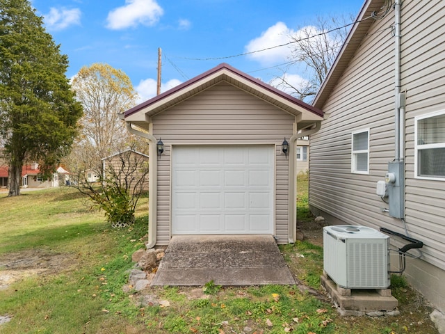 garage with a lawn and central AC unit