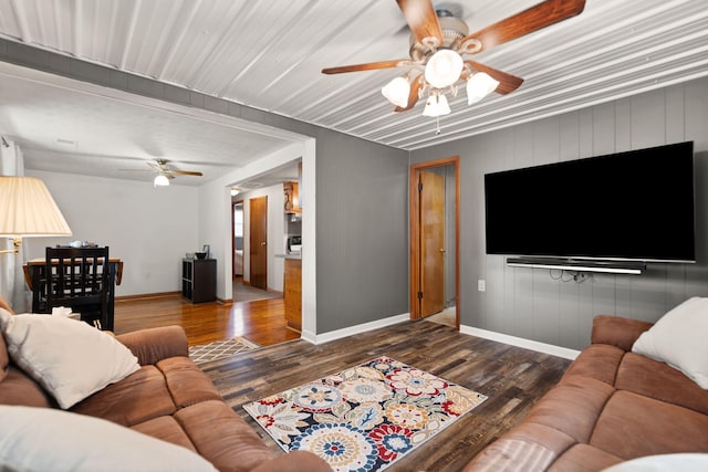 living room featuring ceiling fan and dark hardwood / wood-style floors