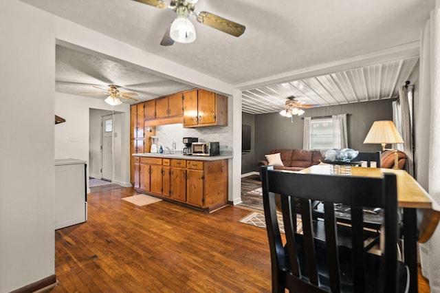 kitchen featuring washer / dryer, tasteful backsplash, dark hardwood / wood-style flooring, beamed ceiling, and sink