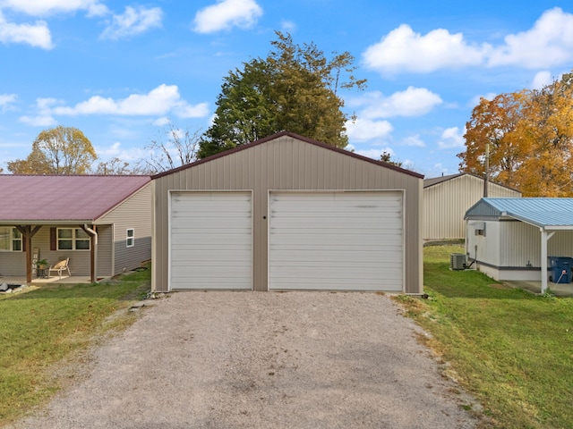 garage with central air condition unit and a lawn