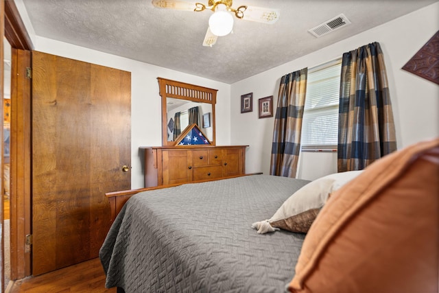 bedroom featuring a textured ceiling and wood-type flooring