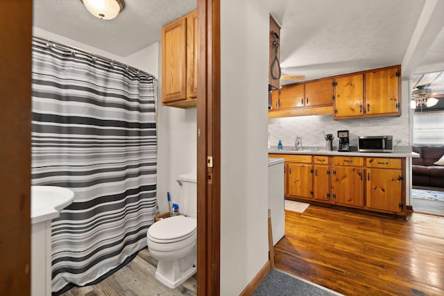 bathroom featuring vanity, hardwood / wood-style floors, toilet, and tasteful backsplash