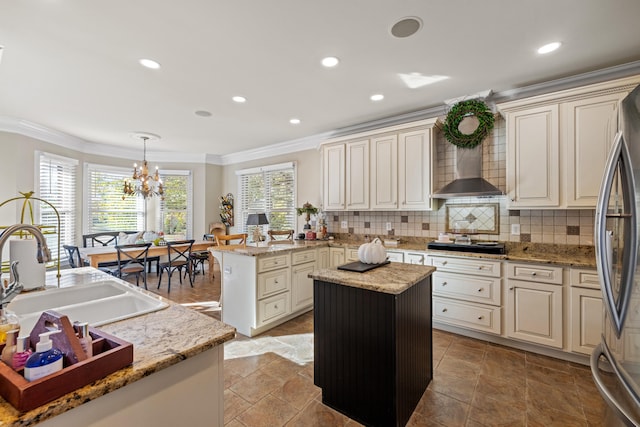 kitchen with pendant lighting, appliances with stainless steel finishes, light stone counters, and a center island