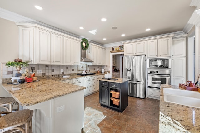 kitchen with a center island, black appliances, tasteful backsplash, ornamental molding, and a kitchen breakfast bar