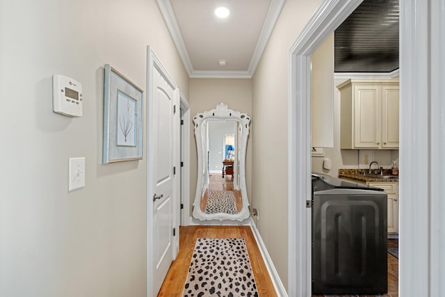 hallway with sink, light hardwood / wood-style flooring, and crown molding