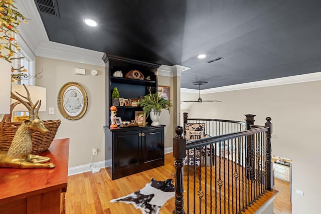 hall with ornamental molding and light hardwood / wood-style flooring