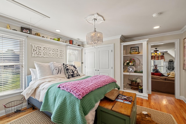 bedroom with ornamental molding, light wood-type flooring, and multiple windows