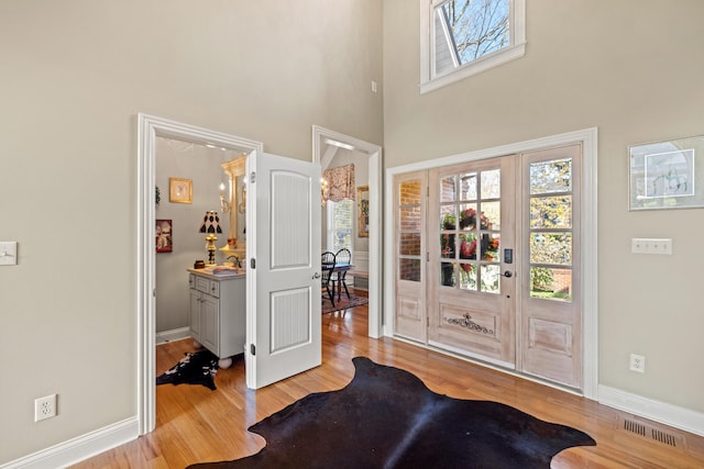 entrance foyer featuring a towering ceiling and light hardwood / wood-style flooring