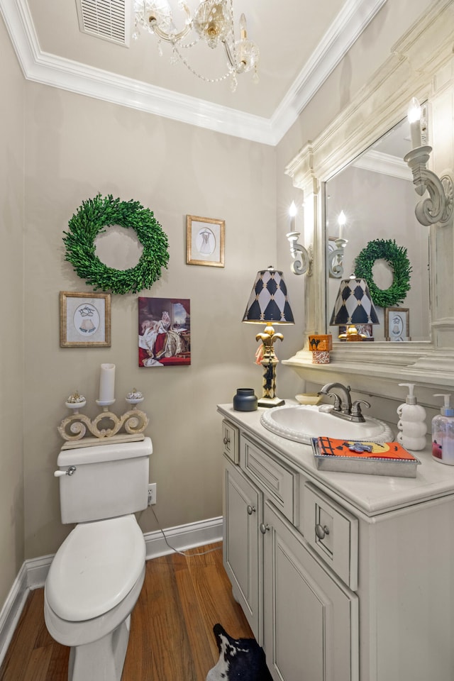 bathroom with toilet, vanity, hardwood / wood-style floors, and ornamental molding