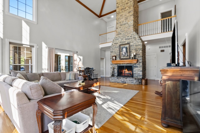 living room with a high ceiling, light wood-type flooring, and plenty of natural light