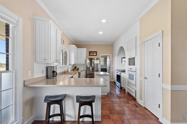 kitchen with a wealth of natural light, white cabinets, and stainless steel appliances