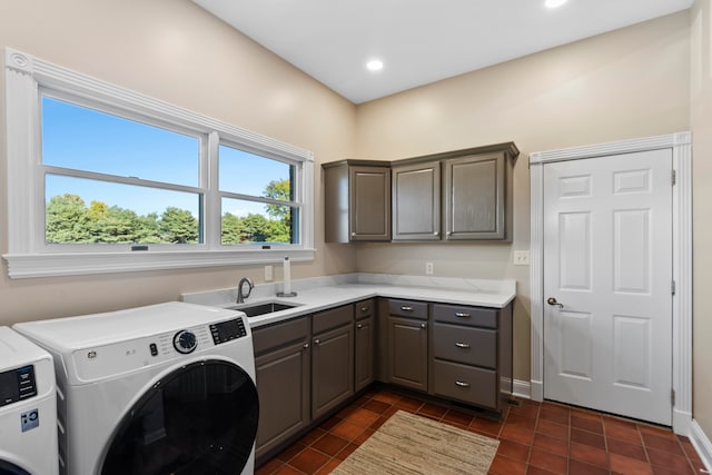 clothes washing area featuring cabinets, sink, separate washer and dryer, and dark tile patterned flooring