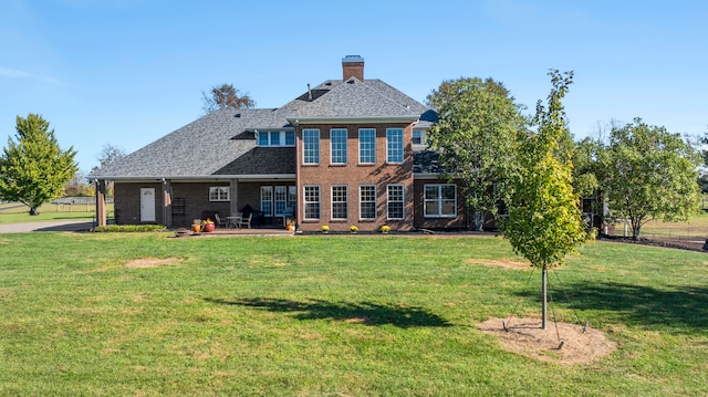 rear view of property with a patio area and a lawn