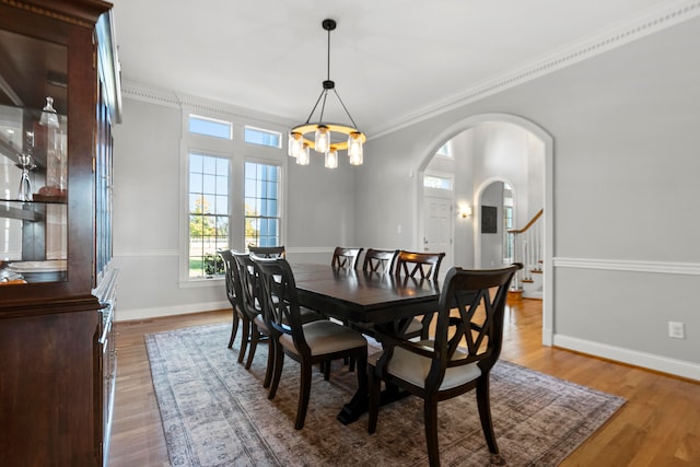 dining area with light hardwood / wood-style flooring, ornamental molding, and a chandelier