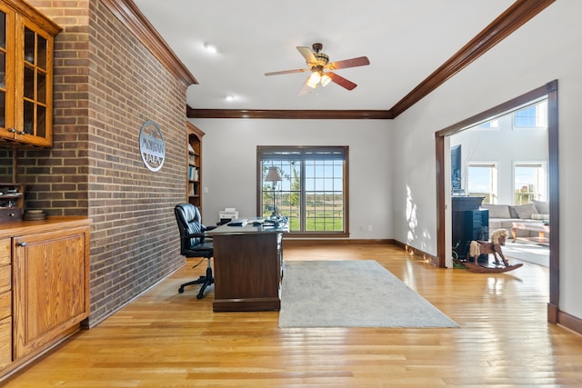 home office with light hardwood / wood-style floors, a healthy amount of sunlight, and ornamental molding