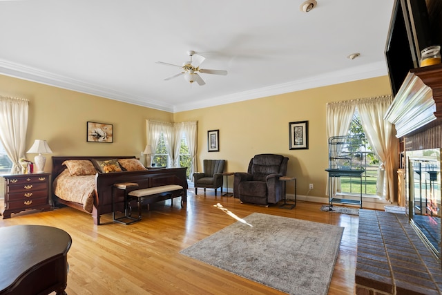 bedroom featuring ornamental molding, multiple windows, hardwood / wood-style floors, and ceiling fan