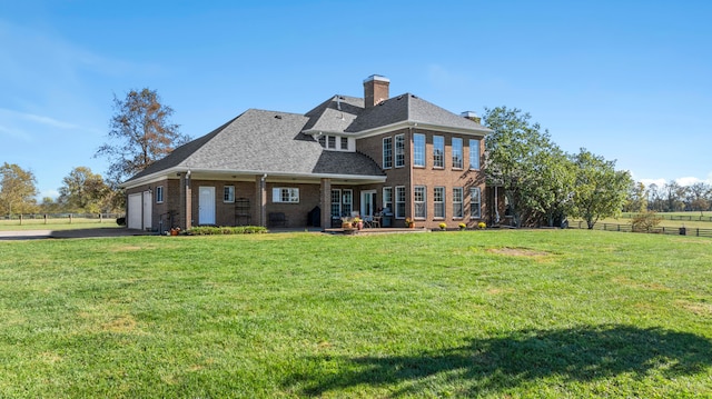 rear view of house with a yard and a patio