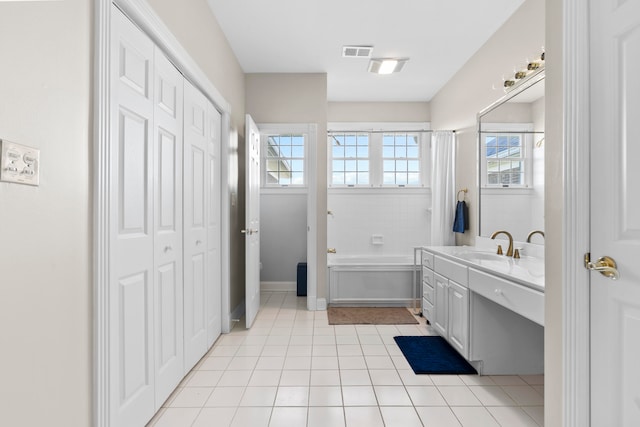 bathroom featuring vanity, a bathing tub, and tile patterned flooring