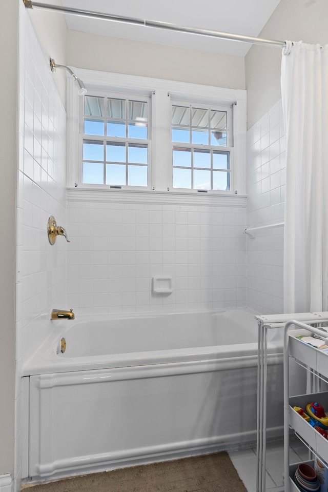 bathroom with a wealth of natural light and shower / tub combo