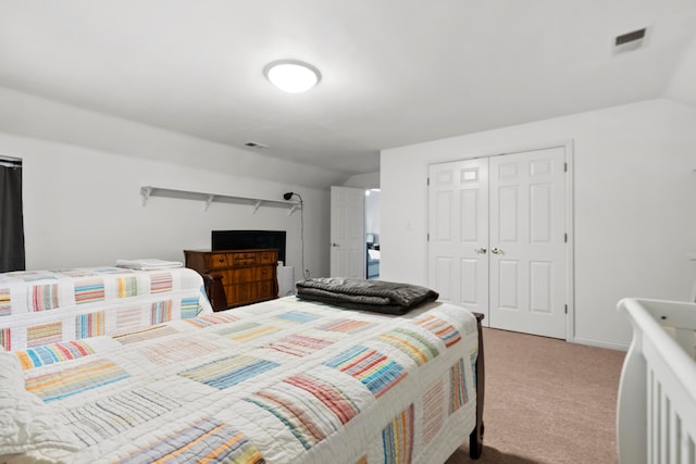 carpeted bedroom featuring a closet and lofted ceiling