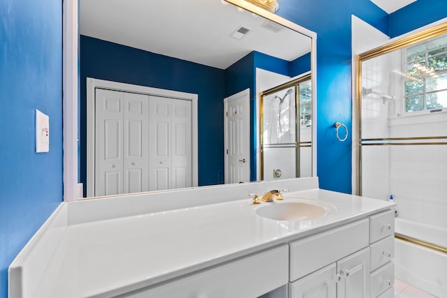 bathroom featuring vanity, enclosed tub / shower combo, and tile patterned floors