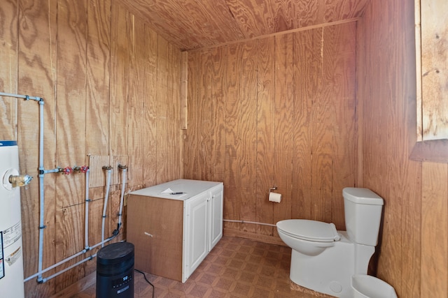 bathroom featuring toilet, water heater, wooden walls, and wooden ceiling