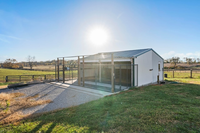 view of outdoor structure with a rural view and a lawn