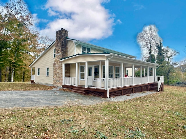 back of property with a porch and a lawn