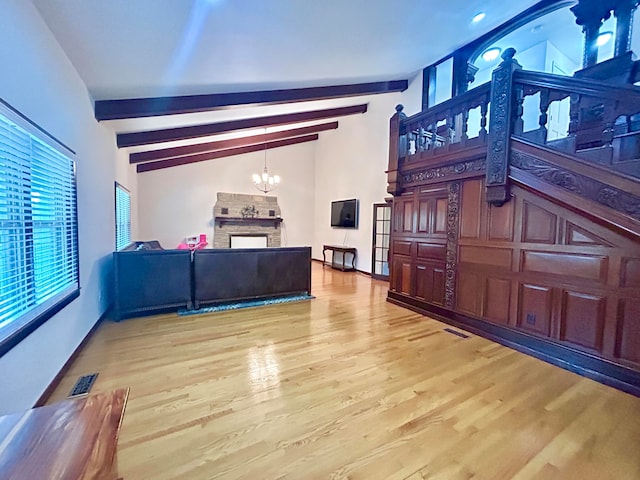 living room with lofted ceiling with beams, hardwood / wood-style floors, and a notable chandelier