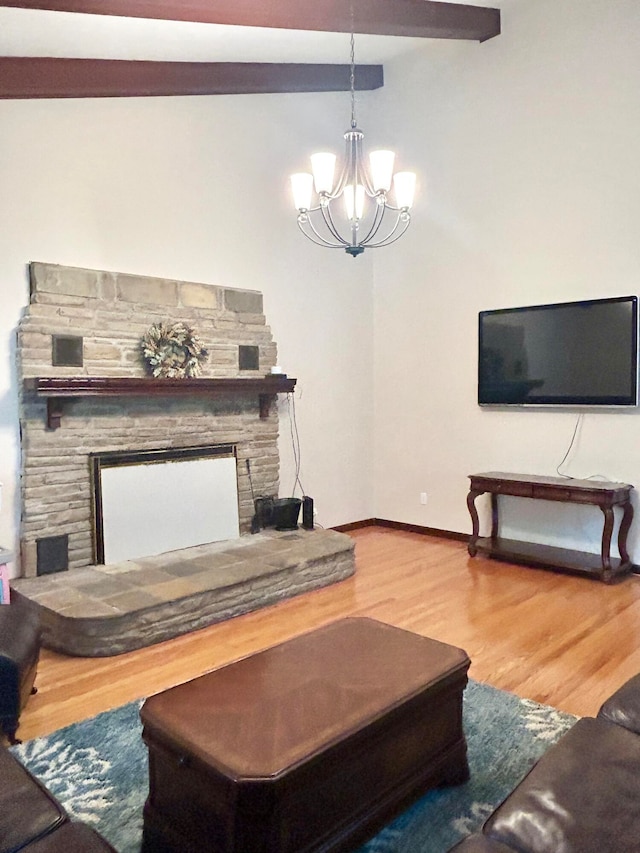 living room featuring beamed ceiling, a chandelier, hardwood / wood-style floors, and a fireplace