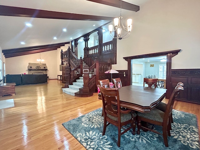 dining room featuring light hardwood / wood-style floors, a chandelier, and beam ceiling