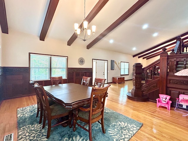 dining room featuring light hardwood / wood-style flooring, a chandelier, and beam ceiling