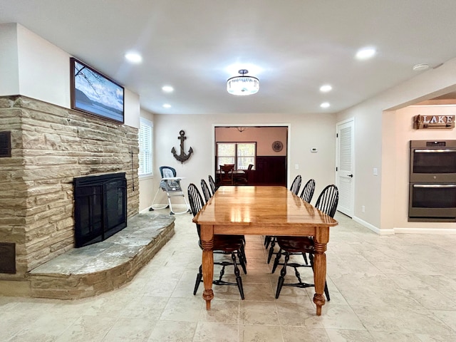 dining room featuring a stone fireplace