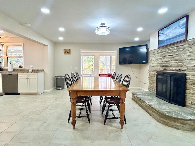 dining space featuring a stone fireplace