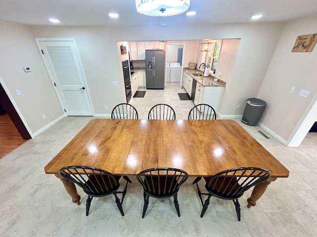 dining space with sink and washer and dryer