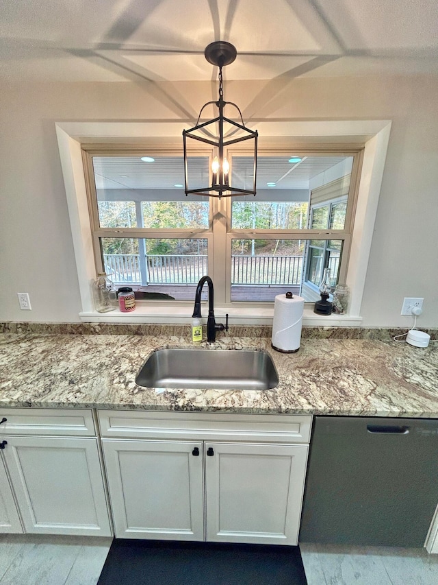 kitchen with a healthy amount of sunlight, sink, decorative light fixtures, and white cabinetry