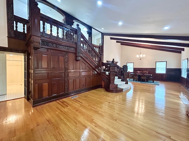 interior space with wood-type flooring, vaulted ceiling with beams, and a chandelier