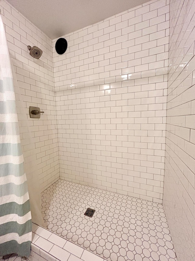 bathroom with walk in shower and a textured ceiling