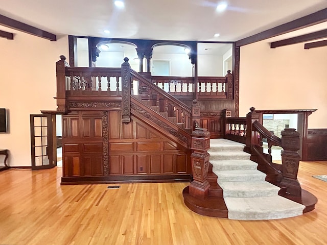 staircase with hardwood / wood-style floors and beamed ceiling