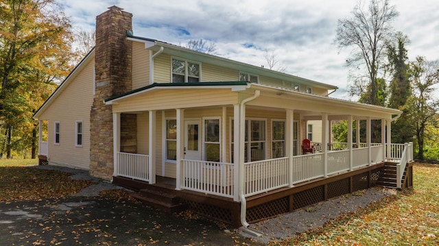 back of property featuring covered porch