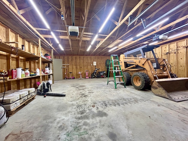 garage featuring wood walls and a garage door opener