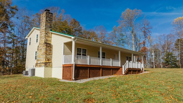 view of front of house with a porch, cooling unit, and a front lawn