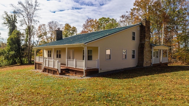 rear view of property featuring a lawn