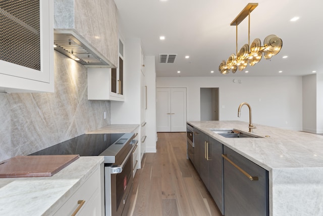 106 W Vine St Unit 407, Lexington, KY 40507 - kitchen with appliances with stainless steel finishes, a sink, a large island with sink, light wood-style floors, and white cabinetry