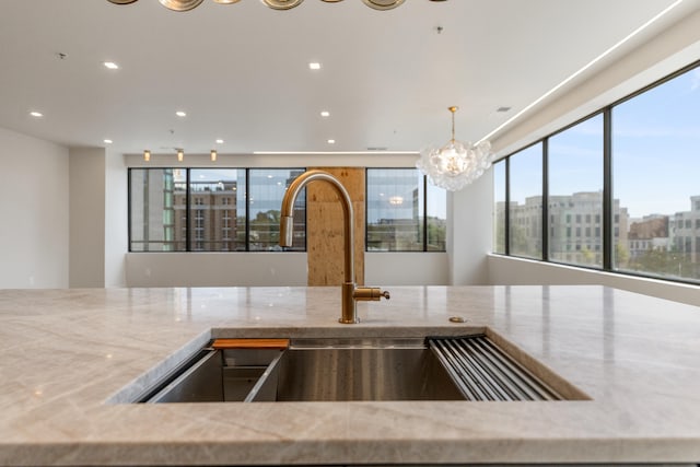 106 W Vine St Unit 407, Lexington, KY 40507 - kitchen featuring a sink, light stone countertops, a chandelier, recessed lighting, and pendant lighting