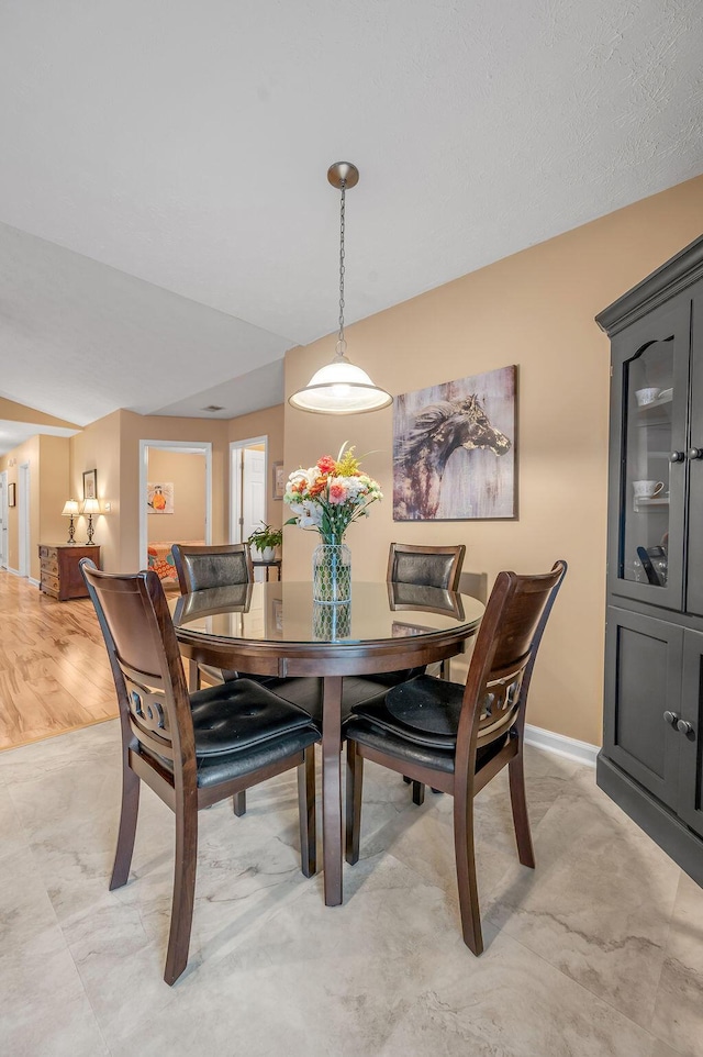 dining space with vaulted ceiling