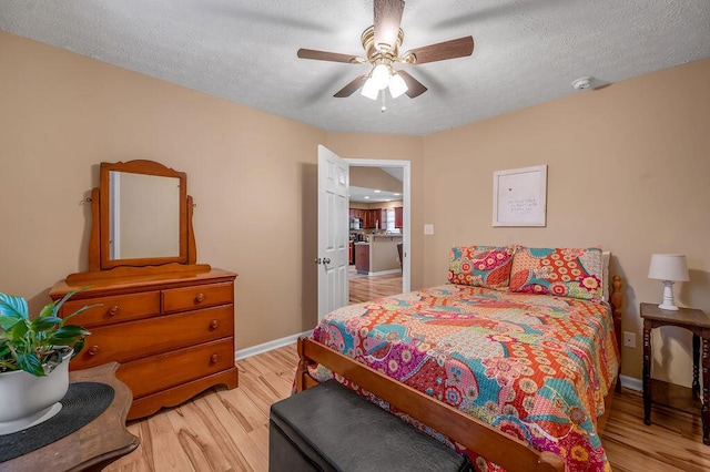 bedroom with ceiling fan, a textured ceiling, and light wood-type flooring