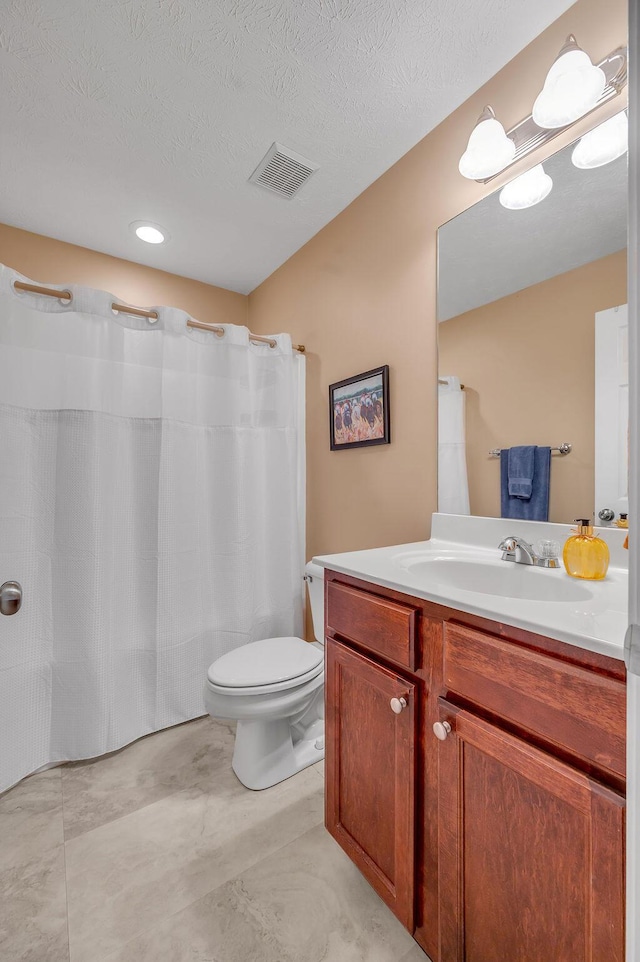 bathroom with vanity, walk in shower, a textured ceiling, and toilet